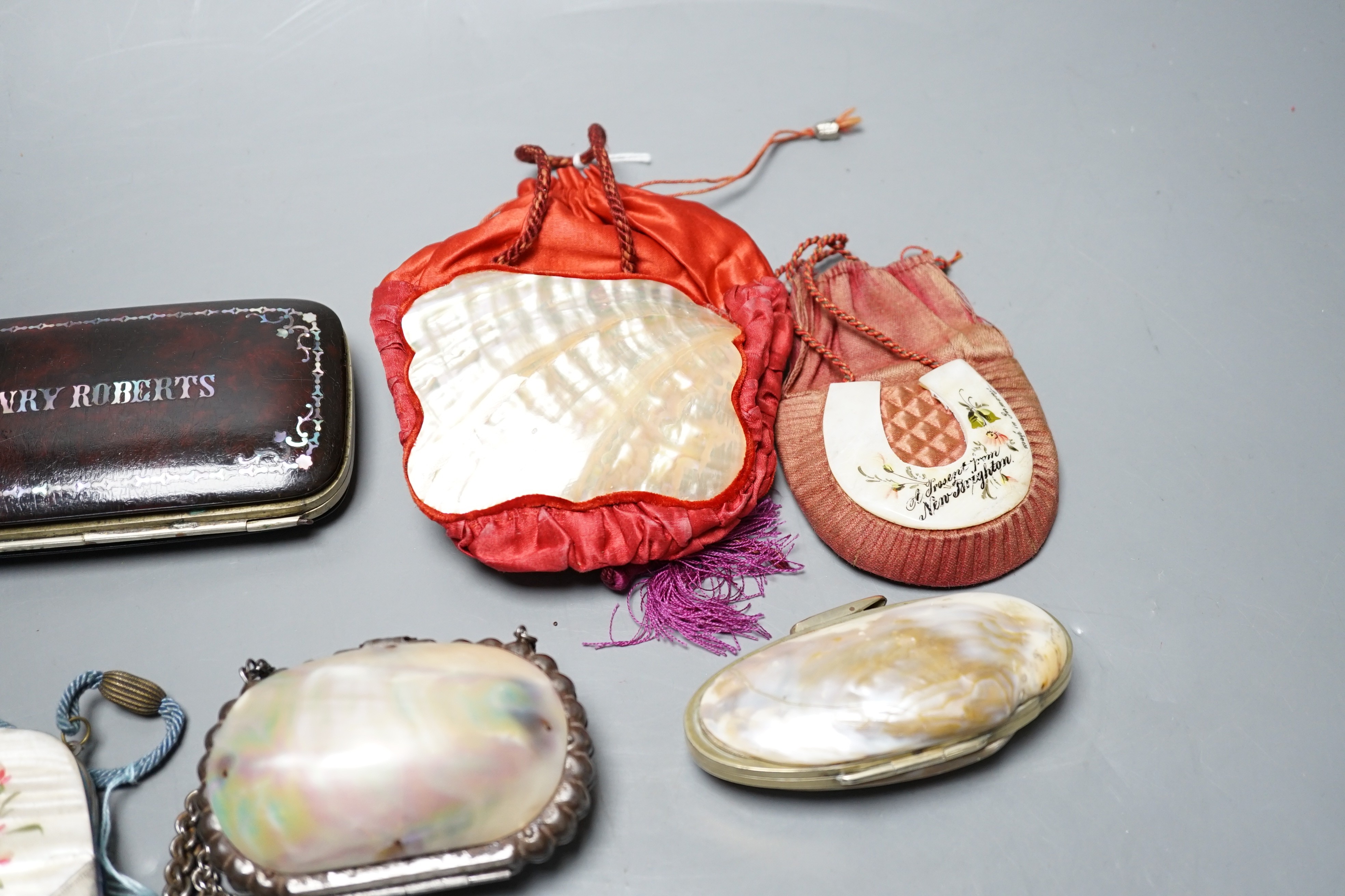 A collection of six mother of pearl souvenir purses, possibly from a grand tour and a papier-mâché mache card case and glasses case, card case 14 cms wide